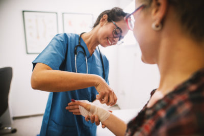 Nurse tending to patient's wound