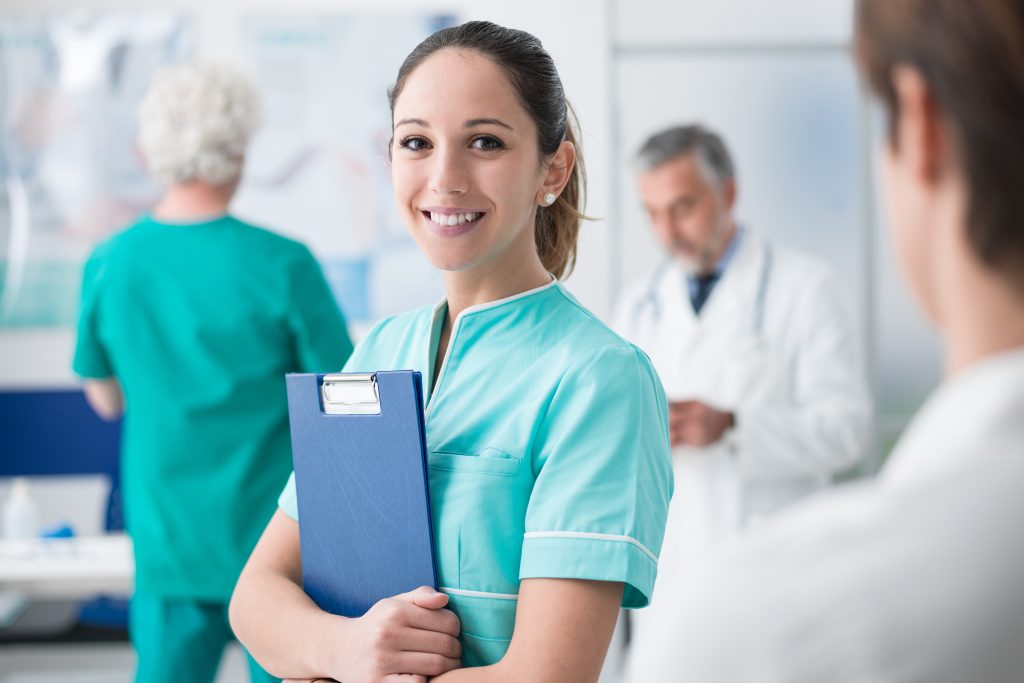 Smiling Nurse Standing in Hospital